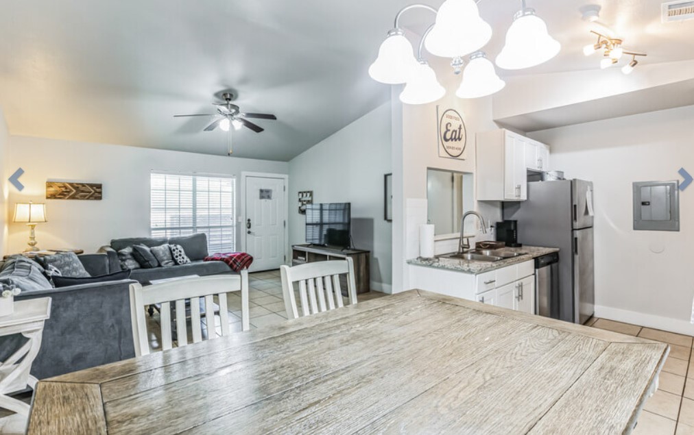 a kitchen and living room with a table and chairs at The Ten19 Apartments